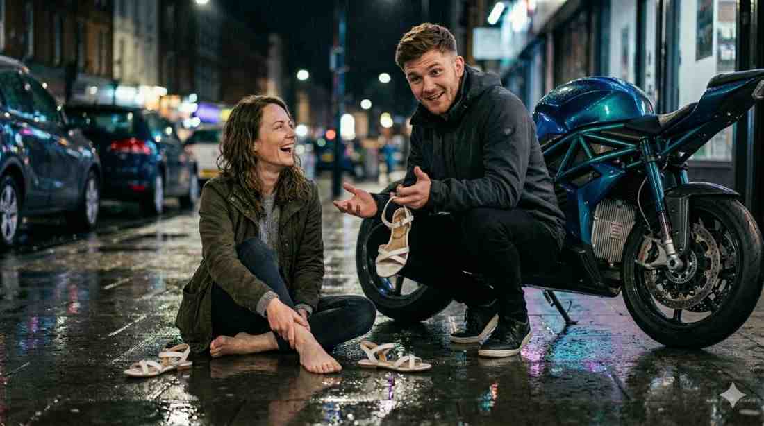 The Stranger Who Stopped A man kneeling on a dark rainy street holding a broken sandal beside a woman sitting on the pavement with a swollen ankle.